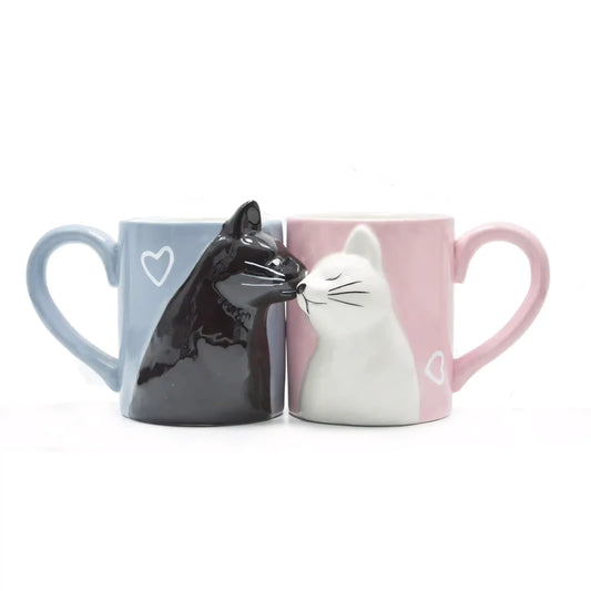 Two mugs shaped like black and white cats on a white background